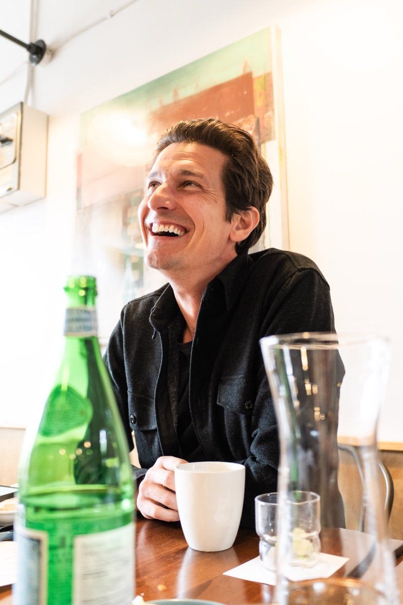 A founder laughing over a cup of coffee